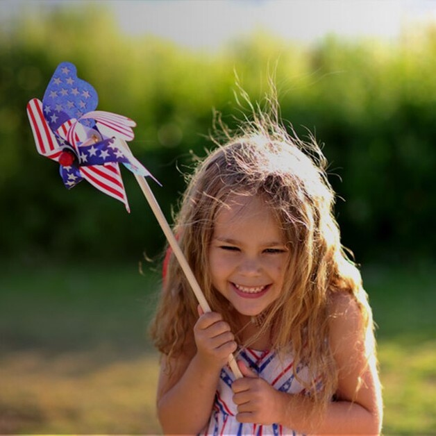 A child smiling holding the American flag